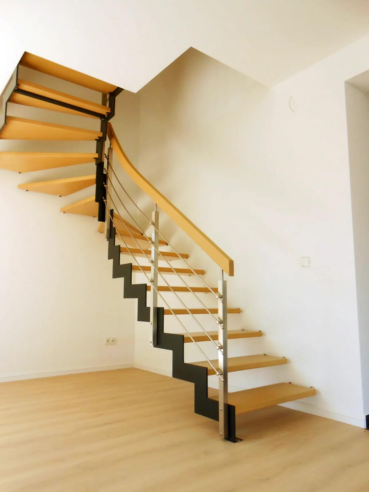 Flachstahltreppe in L-Form (90°-Wendung) – helles Holz, Stahlgeländer – Projekt von Treppen Sonsala