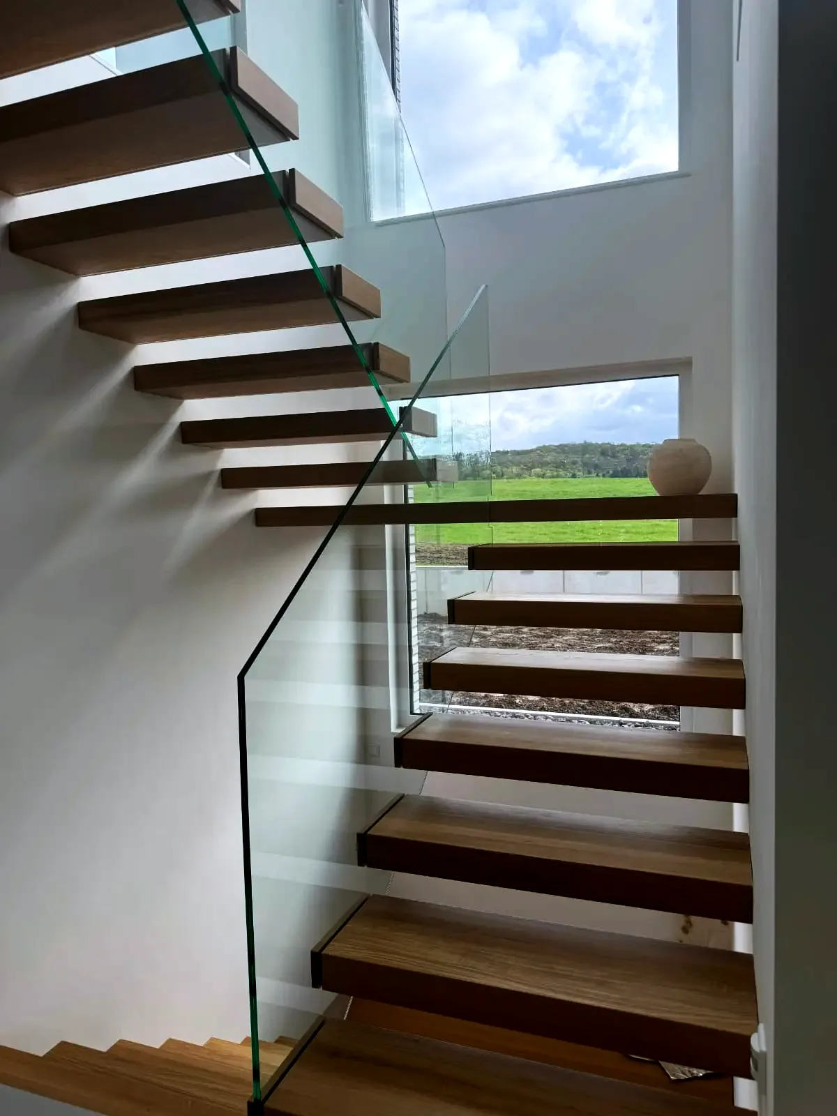 Kragarmtreppe in L-Form (90°-Wendung) – dunkles Holz, Glasgeländer – Projekt von Treppen Sonsala