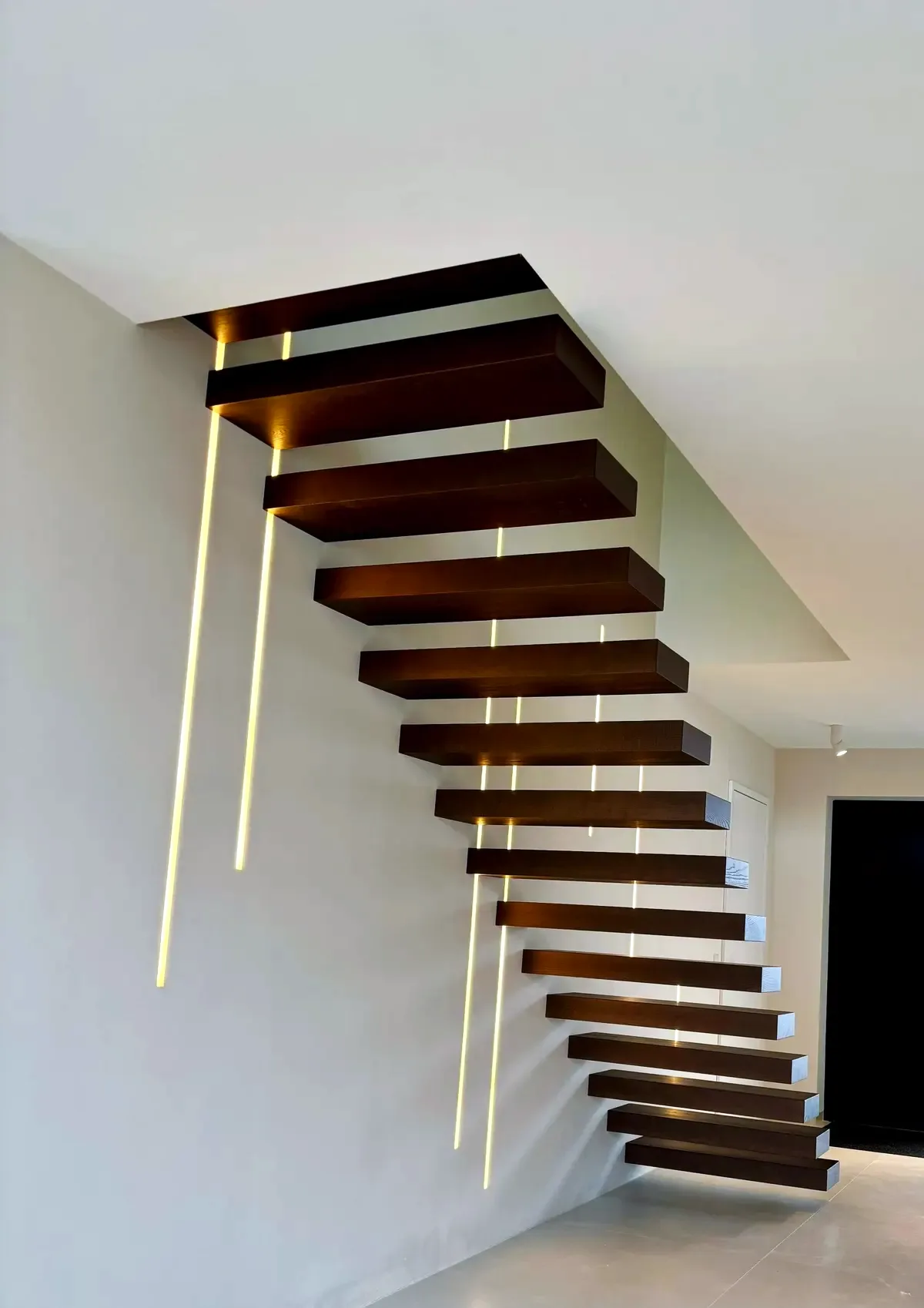 Kragarmtreppe – dunkles Holz, ohne Geländer, LED-Lichtfugen – Projekt von Treppen Sonsala