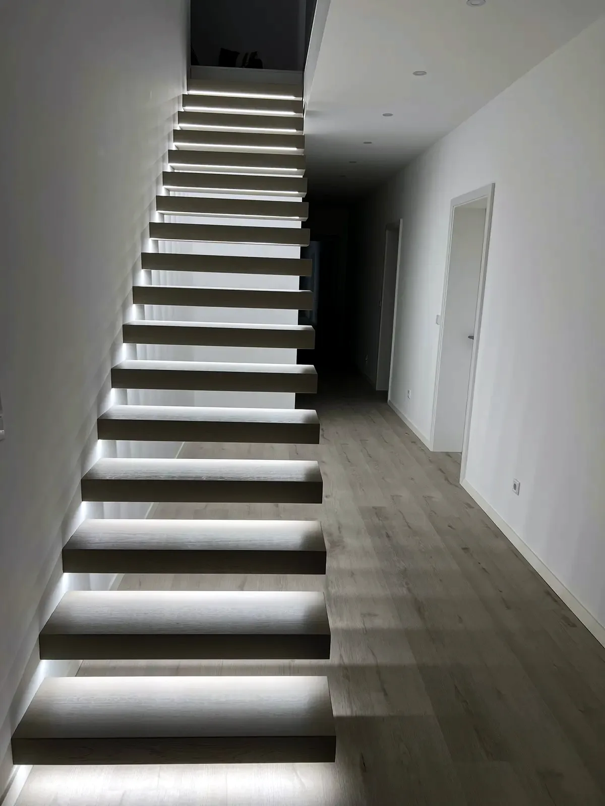 Kragarmtreppe – dunkles Holz, ohne Geländer, LED-Stufenlicht – Projekt von Treppen Sonsala