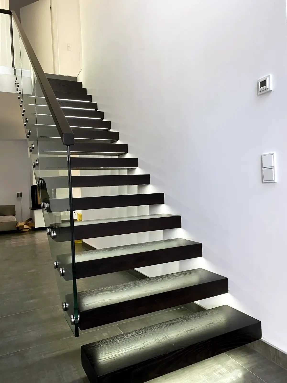 Kragarmtreppe – schwarze Stufen, Glasgeländer, LED-Stufenlicht – Projekt von Treppen Sonsala