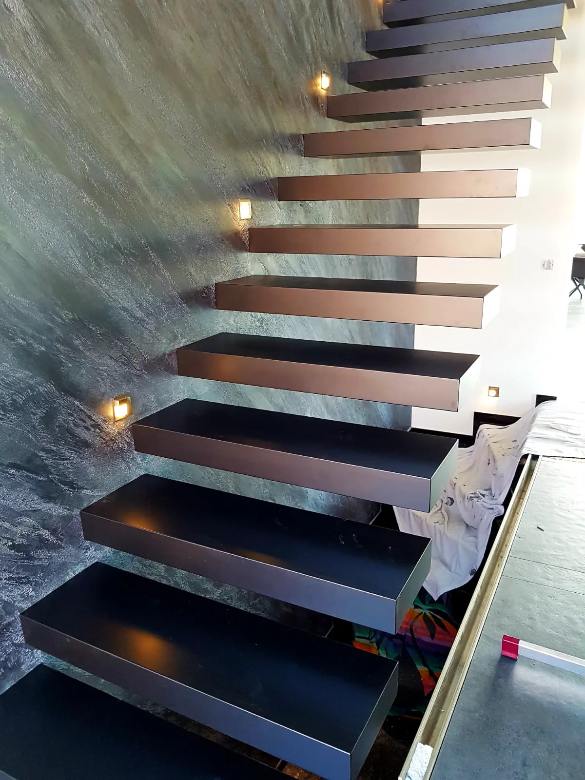 Kragarmtreppe – schwarze Stufen, ohne Geländer, LED-Wandspots – Projekt von Treppen Sonsala