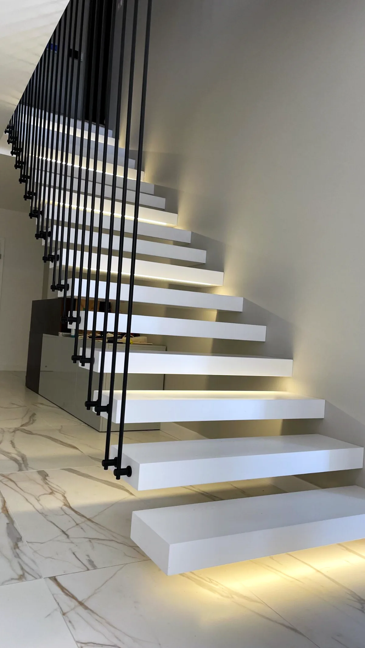 Kragarmtreppe – weiße Stufen, Stahlgeländer, LED-Stufenlicht – Projekt von Treppen Sonsala